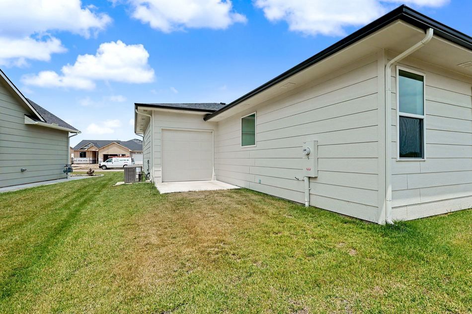 Rear exterior and back lawn at 14007 E Wassall St. — Wichita, KS
