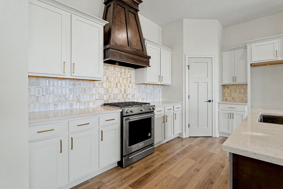 Kitchen with wood range hood and tile backsplash at 2640 S Clear Creek St. — Wichita, KS