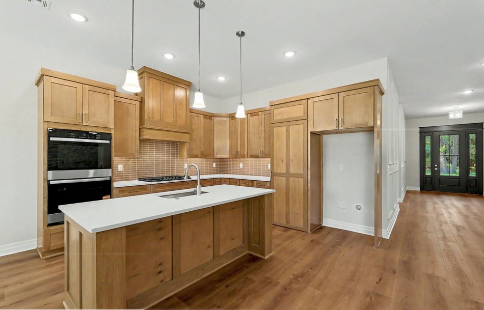 Kitchen at 116 S Byron Road by RJ Castle Homes with maple cabinetry, a double wall oven and a quartz-topped island – Wichita, KS