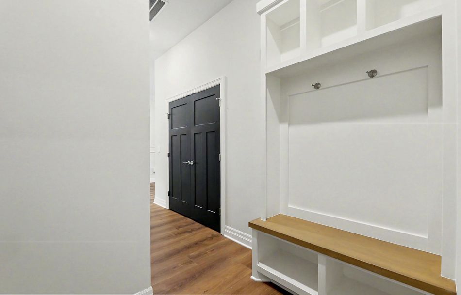 Mudroom at 116 S Byron Road by RJ Castle Homes with a built-in timber bench, panelled back and cubbies under – Wichita, KS