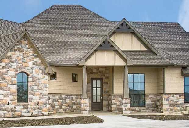 RJ Castle Homes custom home entry with stone facade and timber gable brackets – Wichita, KS