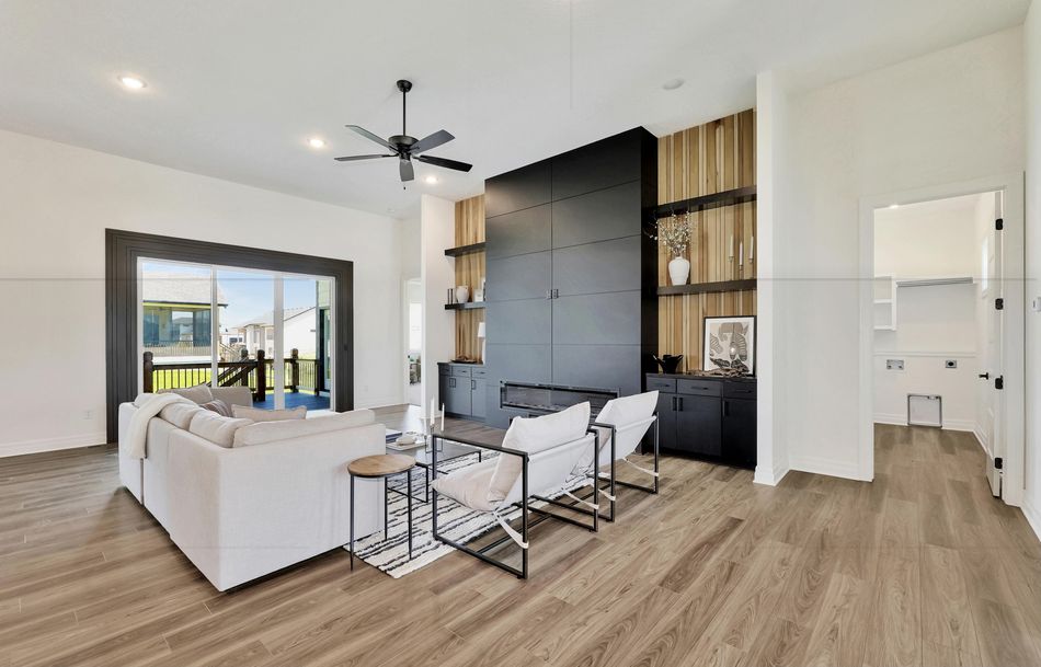 Great room at 2579 Doris Court with a full-height black tile fireplace wall between oak-slat shelving bays – Wichita, KS