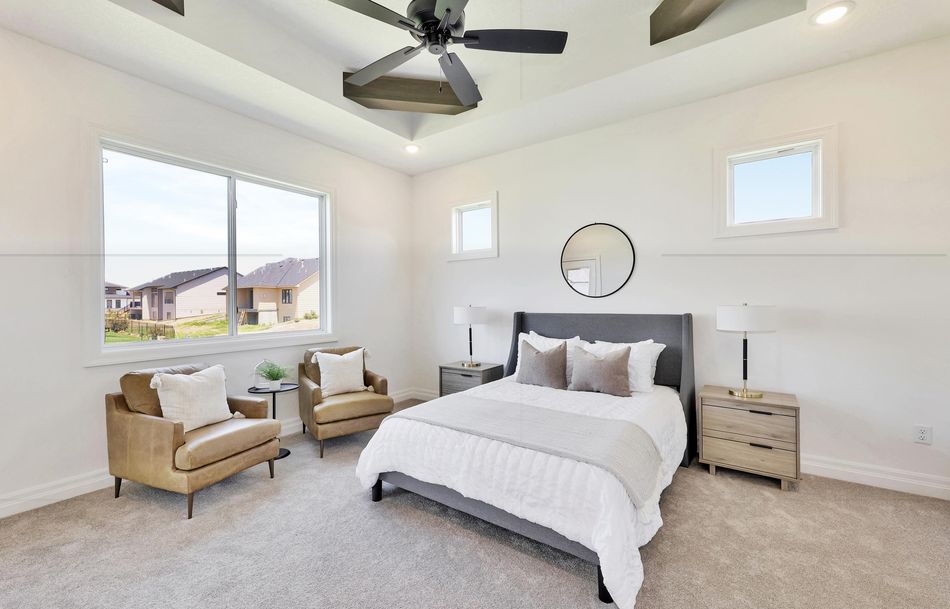Primary bedroom at 2579 Doris Court with a stepped tray ceiling, corner windows and carpet – Wichita, KS