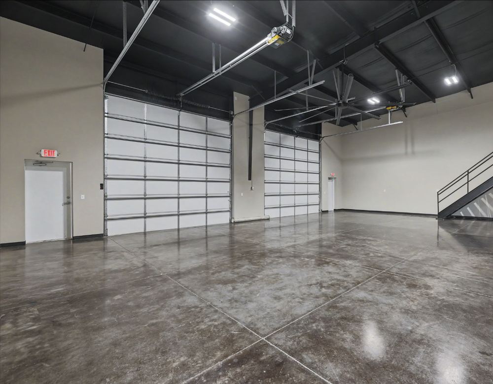 Eagle Lux garage condo bay with black steel stairs rising to the mezzanine and an unobstructed concrete floor – Maize, KS