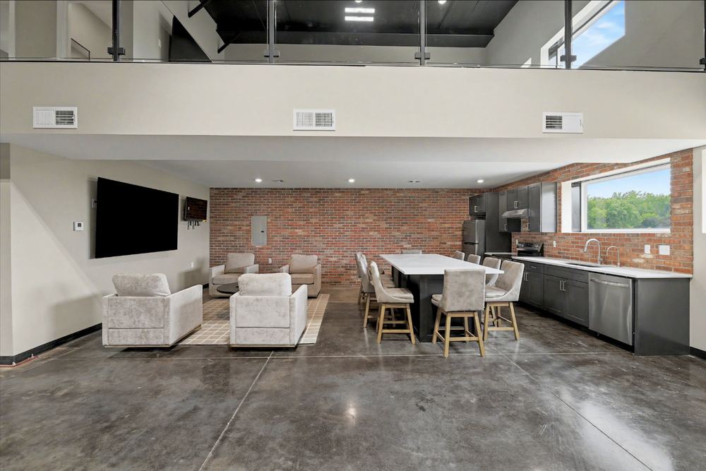 Eagle Lux garage condo lounge and kitchenette with brick feature wall, stainless appliances and quartz-look counter – Maize, KS