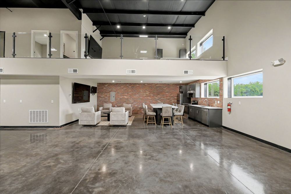 Eagle Lux garage condo finished out with a glass-railed mezzanine and brick-walled lounge – Maize, KS