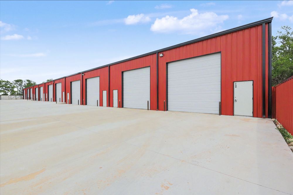 Row of white overhead doors on the red steel Eagle Lux garage condo building – Maize, KS