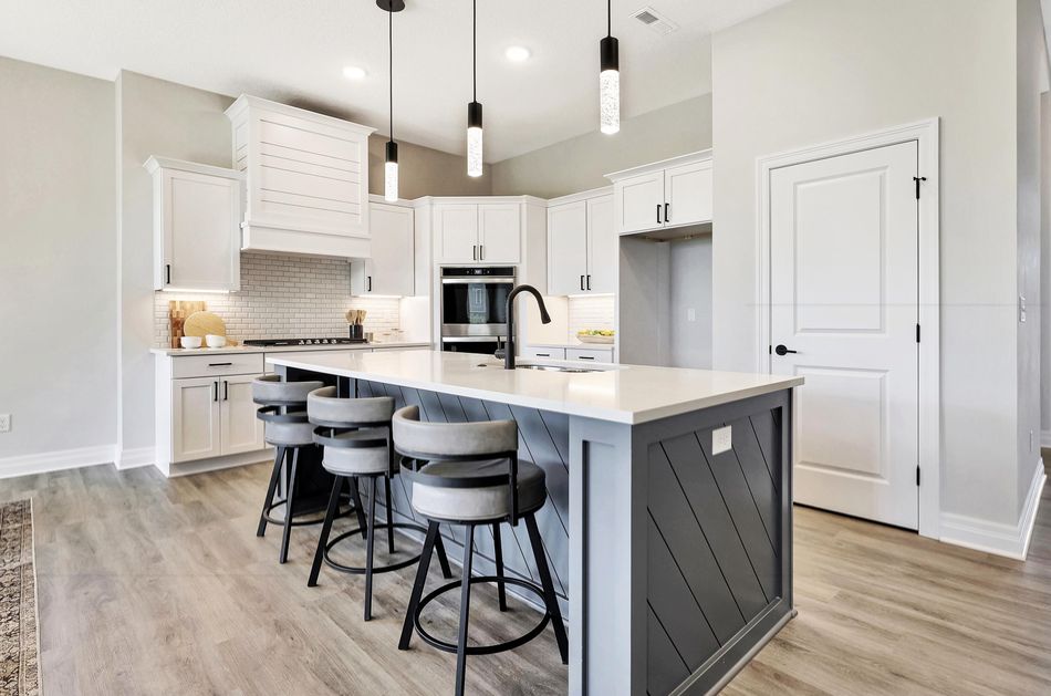 Kitchen at 4658 W Emerald Bay Court with white cabinetry, a panelled charcoal island and a shiplap hood surround – Wichita, KS