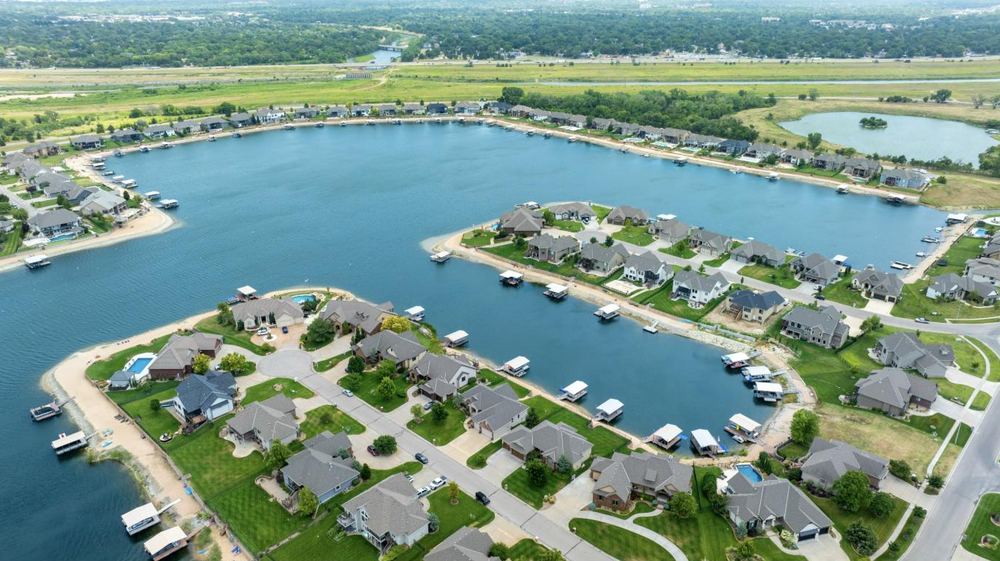 Aerial view of the Emerald Bay Estates community lake ringed by homes and private docks – Wichita, KS