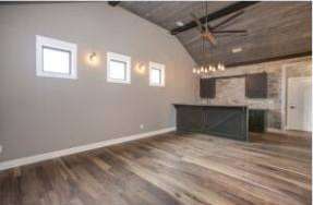 Completed RJ Castle Homes great room with wood-plank vaulted ceiling and wet bar – Wichita, KS