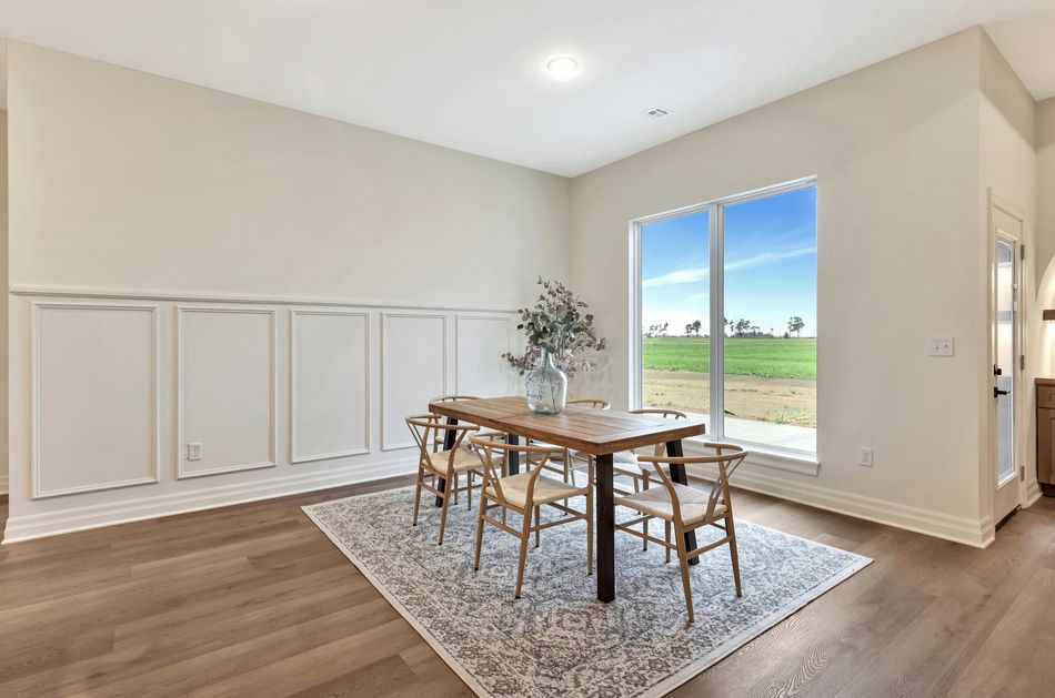 Dining room at 13650 W Homestead Drive with full-height wall panelling and a picture window onto open farmland – Colwich, KS