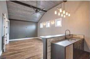 RJ Castle Homes custom kitchen with island and vaulted plank ceiling – Wichita, KS