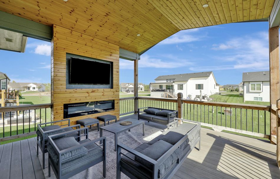 Covered rear deck at 5915 W Kollmeyer Court with a knotty cedar ceiling, linear fireplace and mounted screen – Wichita, KS