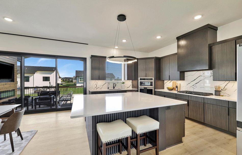 Contemporary kitchen with a full-slab quartz backsplash and a fluted island in a home featured on our work page at 5915 W Kollmeyer Court – Wichita, KS