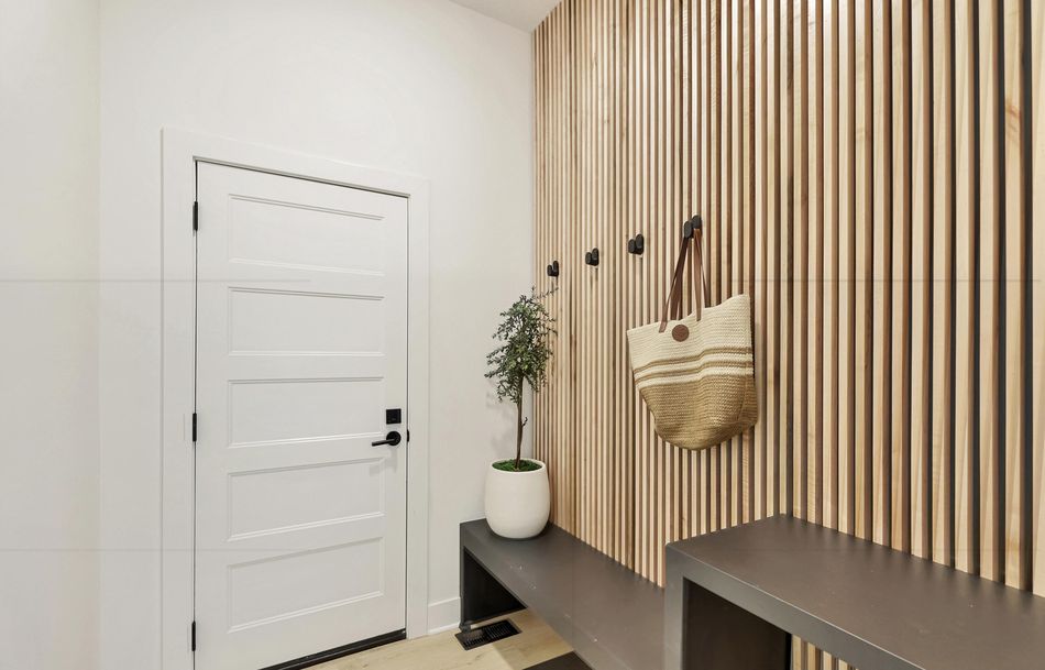 Mudroom at 5915 W Kollmeyer Court with a full-height oak slat wall, black hooks and a floating bench – Wichita, KS