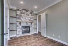 RJ Castle Homes living room with stone fireplace and built-in shelving – Wichita, KS