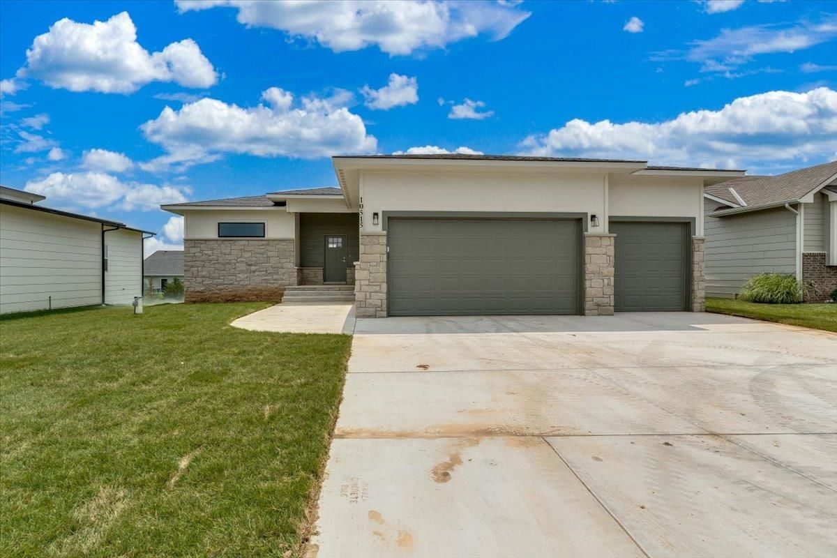 Front exterior of 10515 W Basil St with stone accents and a 3-car garage, an RJ Castle home in Southern Ridge, Wichita, KS