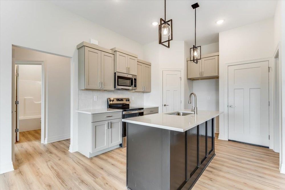 Kitchen with island, pendant lights and stainless appliances at 10515 W Basil St, Wichita, KS