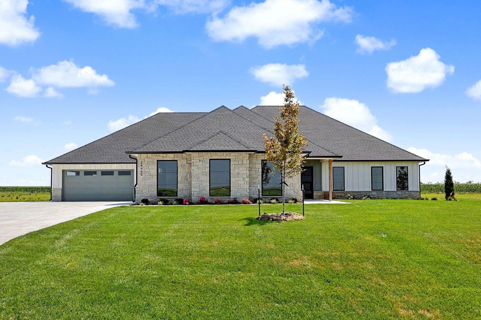 Front exterior of 24465 W Stonebottom Ct, a single-level stone and siding RJ Castle home on 2.15 acres in Stonewater near Goddard, KS