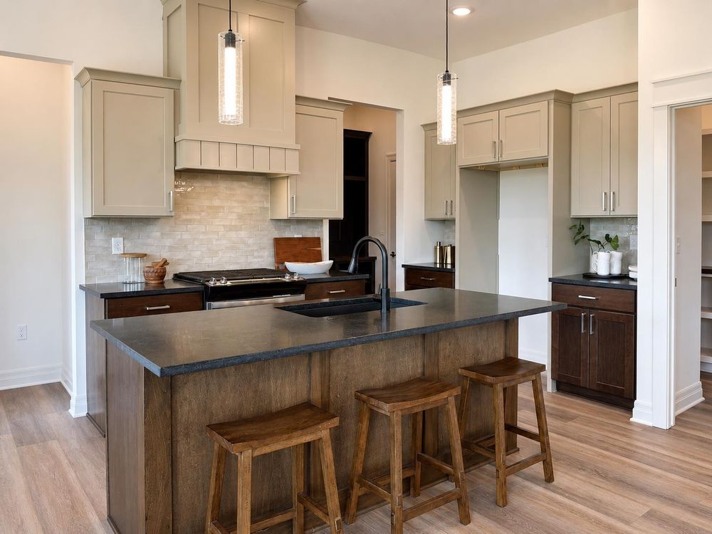 Kitchen with a stained wood island, dark counters and bar seating at 5857 N St. Paul Ct, Wichita, KS