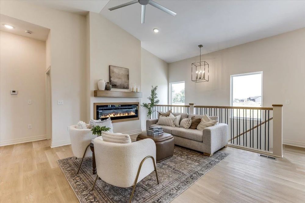 Great room with a linear fireplace under a vaulted ceiling at 8880 E Bradford St, Derby, KS