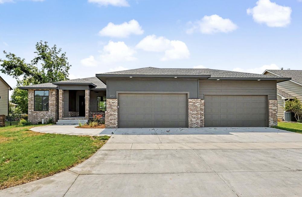 Front elevation of 3117 Sunflower Drive by RJ Castle Homes — charcoal stucco and lap siding over brick with a deep concrete drive – Derby, KS