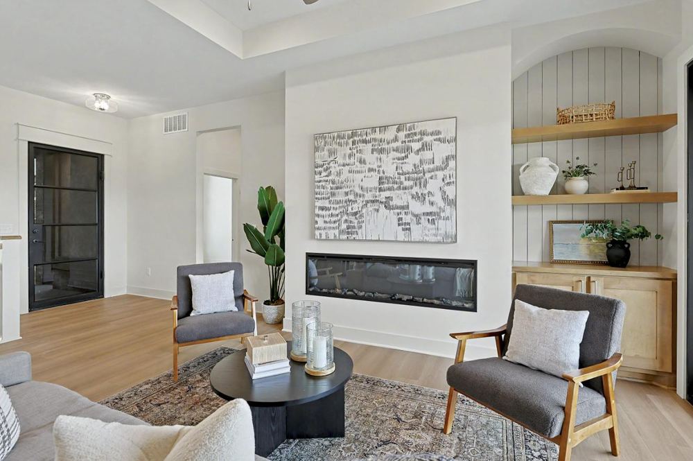 Living room at 3117 Sunflower Drive with a linear fireplace and a panelled alcove of built-in shelving – Derby, KS