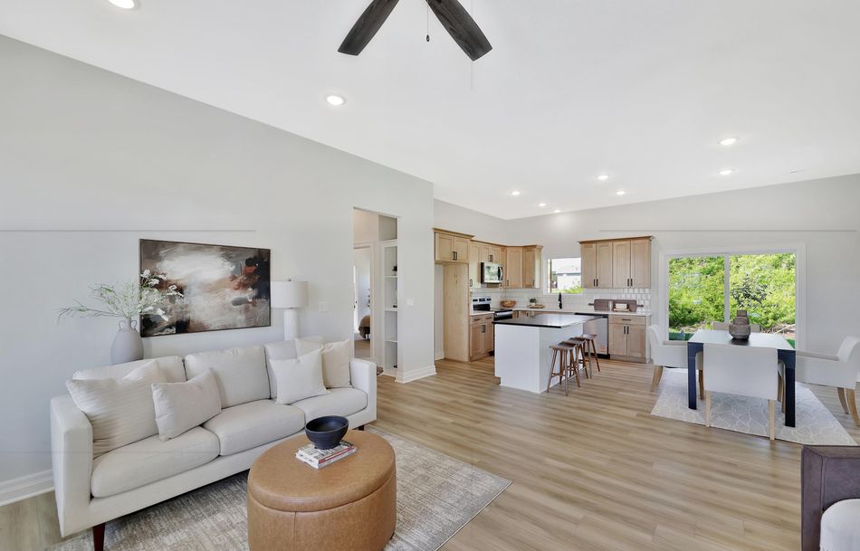 Great room at 517 S Sweetwater Road under a vaulted ceiling, open through to the kitchen and dining area – Maize, KS